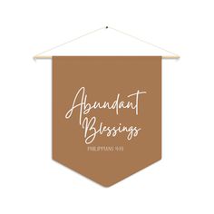 a brown banner with the words, abundant blessings on it hanging from a wooden hanger