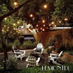 an outdoor patio with lights strung over the trees and lawn chairs in the foreground