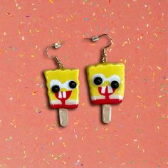 Add a touch of humor and nostalgia to your style with these one-of-a-kind handmade polymer clay earrings featuring a funny melted SpongeBob popsicle design!💫 Inspired by the beloved childhood treat, these earrings capture the quirky, imperfect charm of those popsicles that never quite matched the picture on the wrapper.   Each earring measures approximately 1"x1.5" and is carefully handcrafted from polymer clay, making every piece unique in its own way.✨ No two earrings are exactly alike, ensuring that you get a truly one-of-a-kind accessory. Coated with a layer of resin for a glossy finish, these earrings are also waterproof, making them durable and perfect for everyday wear. ️ Choose your earring hook color from gold or silver, with each pair featuring stainless steel hooks for a comfor Weird Clay Earrings, Spongebob Earrings, Spongebob Popsicle, Spongebob Outfit, Popsicle Earrings, Popsicle Design, Silly Earrings, Crazy Earrings, Earrings Funny