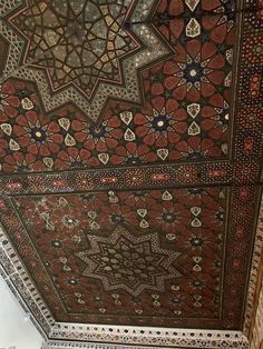 an intricate ceiling in the middle of a room with many different designs on it, including stars and circles