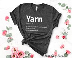 a t - shirt with the words yarn on it and pink flowers in the background