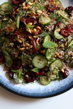 a blue and white plate topped with cucumbers, nuts and other food items