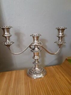 a silver candelabra sitting on top of a wooden table