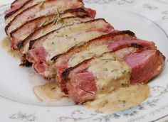 slices of meat sitting on top of a white plate