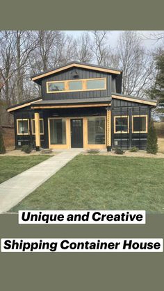 a small black and yellow house in the grass