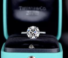 an engagement ring in a blue box with the words tiffany co written on it's side