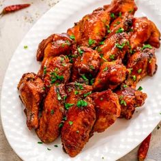 a white plate topped with chicken wings and garnished with parsley