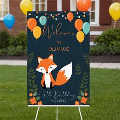 a welcome sign in the grass with balloons