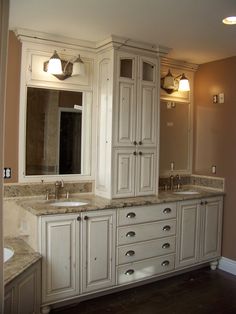 a large bathroom with two sinks and cabinets in it's center area, along with a bathtub