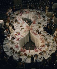 a group of people sitting around a large table with plates and silverware on it