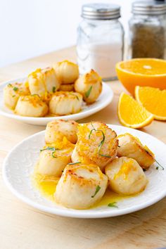 two white plates with scallops and orange slices