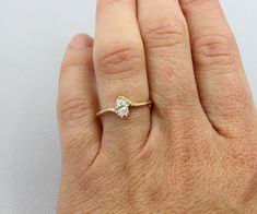 a woman's hand with a diamond ring on top of her left hand,