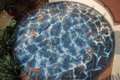 a circular mosaic table with fish on it