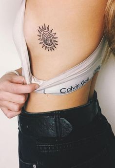 a woman with a sun tattoo on her stomach