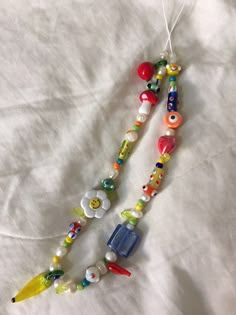 a long beaded necklace with colorful beads and charms hanging from it's end