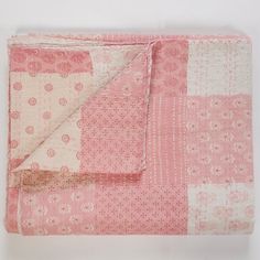 a pink and white patchwork quilt with polka dots