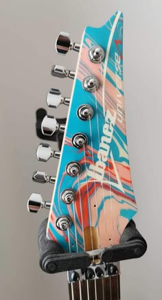 an electric guitar with its neck up and the heads turned upside down, in front of a gray background