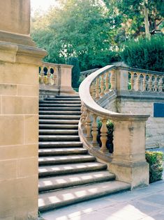 a stone staircase with railing and planters next to it