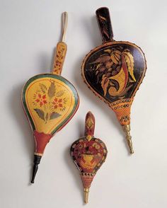 three decorative items are displayed on a white surface, including an antique fan and a vase