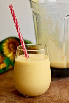 a smoothie in a glass next to a blender