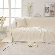 a living room with white furniture and flowers