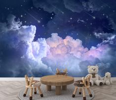 two teddy bears sitting at a table in front of a night sky with stars and clouds