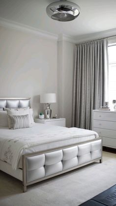 a white bed sitting in a bedroom next to a window