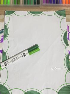 a green marker sitting on top of a piece of paper next to some crayons