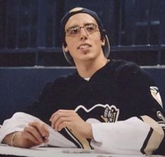 a woman sitting at a table with a hockey jersey on