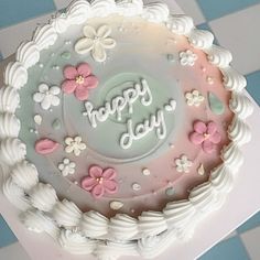 a birthday cake with white frosting and pink flowers on it that says happy day