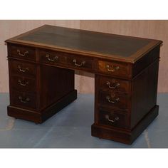 an antique wooden desk with three drawers and one drawer on the top, in front of a wall