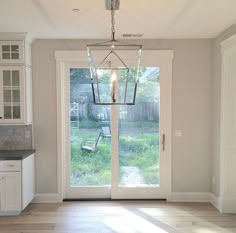 an empty kitchen and dining room with french doors leading to the back yard, outside