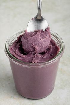 a spoon in a jar filled with purple ice cream