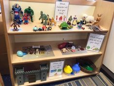 a book shelf filled with lots of toy figurines on top of wooden shelves