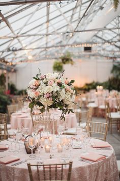 an indoor wedding reception with pink and white flowers