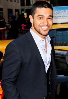 a man in a suit standing next to a taxi