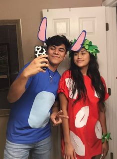 a man and woman taking a selfie in front of a door with bunny ears on