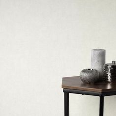 a wooden table topped with two vases next to a candle on top of it