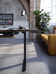 a desk with a computer on it and a chair in front of the table next to it