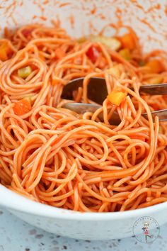 a white bowl filled with spaghetti and vegetables