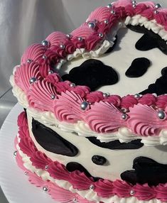 a pink and black cake on a white plate