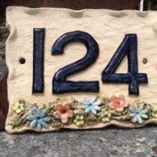 a house number sign with flowers on it