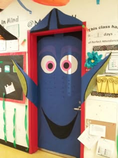 the door is decorated with an image of a blue monster in front of it, and there are other decorations on the wall