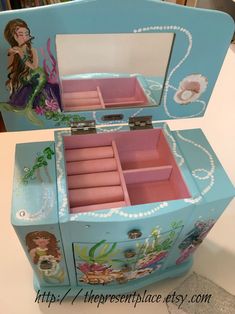 "This is a wonderful jewelry box, it is big enough for any little girl to grow into. It has many compartments for hanging jewelry, rings and bracelets too.This jewelry box was painted pink . The lid of the box has a mermaid and the child's name on it. Inside the lid is a mirror and a deep drawer that has a place for rings and two additional compartments, this drawer is 4 1/2\" x4\" and it is 1 3/4\" deep. There is space at the beck to add a personal message. This box has two side panels that ope Painted Box Ideas, Ballerina Box, Hanging Jewelry Box, Kids Jewelry Box, Pink Jewelry Box, Rings And Bracelets, Painted Box, Girls Jewelry Box, Custom Jewelry Box