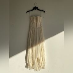 a dress hanging up against a wall with the sun shining on it's back