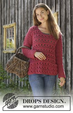 a woman in a red sweater is holding a basket and posing for the camera with her hand on her hip