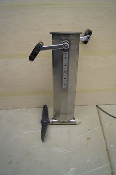 a metal object with two knives sticking out of it's back end on the floor