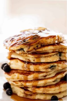 a stack of pancakes with blueberries and syrup