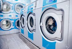 a row of washers in a public laundment with blue and white walls