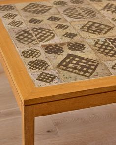 a close up of a wooden table with decorative tiles on the top and bottom surface